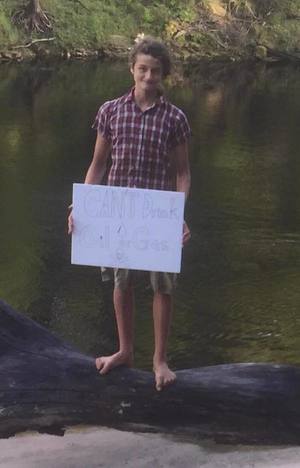 A young activist. His sign says cant drink oil or gas.