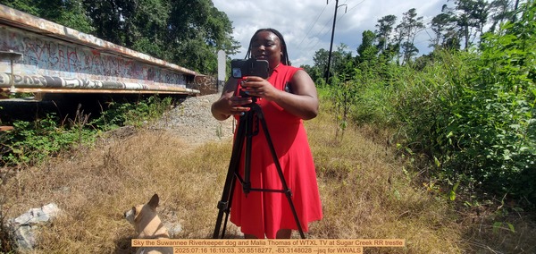 [Sky the Suwannee Riverkeeper dog and Malia Thomas of WTXL TV at Sugar Creek RR trestle, 2025:07:16 16:10:03, 30.8518277, -83.3148028 --jsq for WWALS]