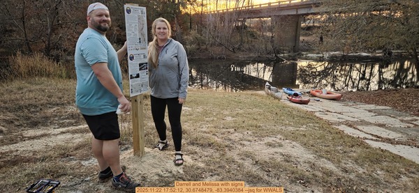 [Darrell and Melissa with signs, 2025:11:22 17:52:12, 30.6748479, -83.3940384 --jsq for WWALS]