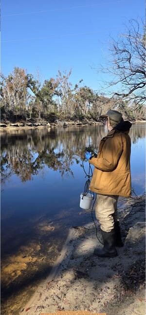 [Ready to throw bucket to get water sample, 2025:12:20 11:58:15, 30.3657478, -83.1915831 --Merrillee Malwitz-Jipson for WWALS]