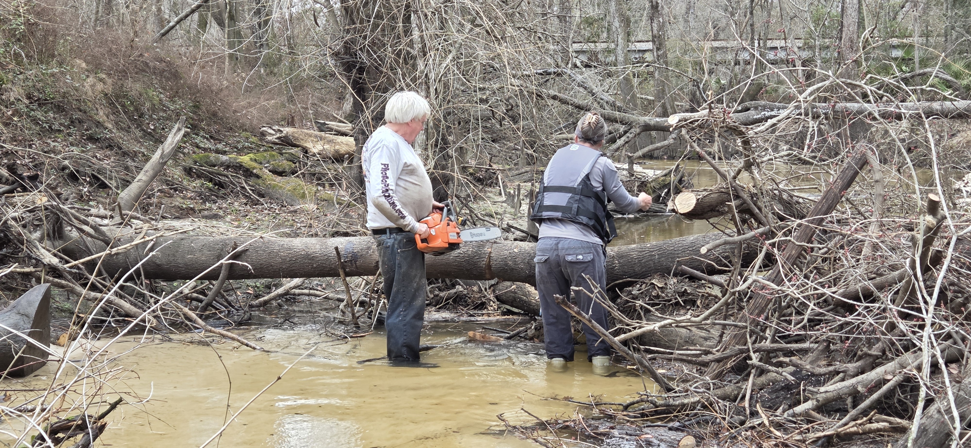 Tish Hall holding the Stihl saw while Phil uses the Husqvarna, 2026:02:14 15:52:54, 30.8638074, -83.3210007