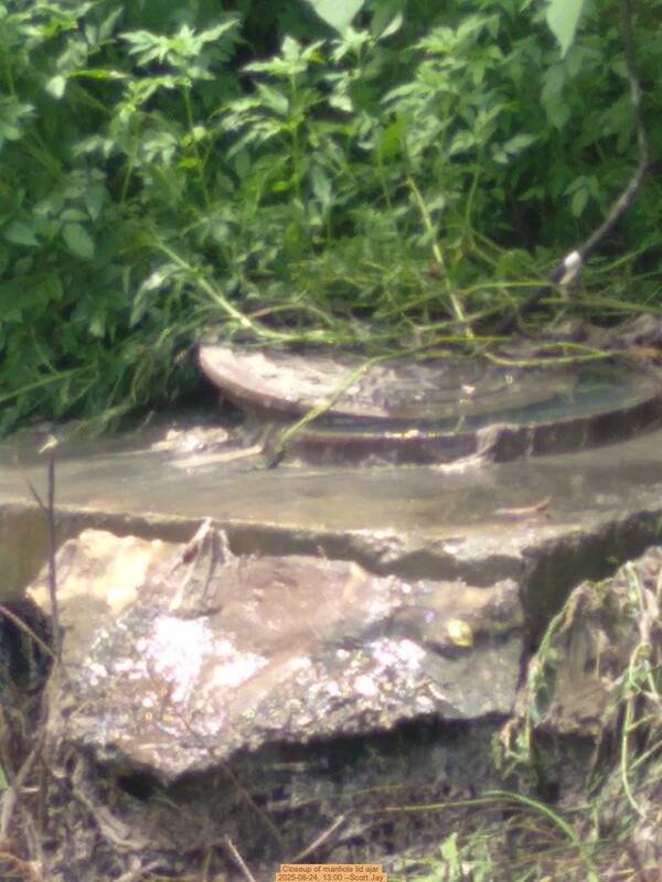 [Closeup of manhole lid ajar, 2025-08-24, 13:00 --Scott Jay]