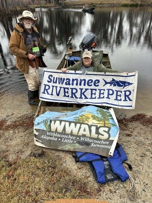 [jsq and Sheila Willis with banners at Banks Lake, 2025:12:04 16:09:46, 31.0350075, -83.0970670 --Teresa Ammons for WWALS]