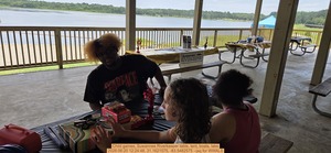 [Child games, Suwannee Riverkeeper table, tent, boats, lake, 2026:06:20 12:24:48, 31.1621575, -83.5482575 --jsq for WWALS]